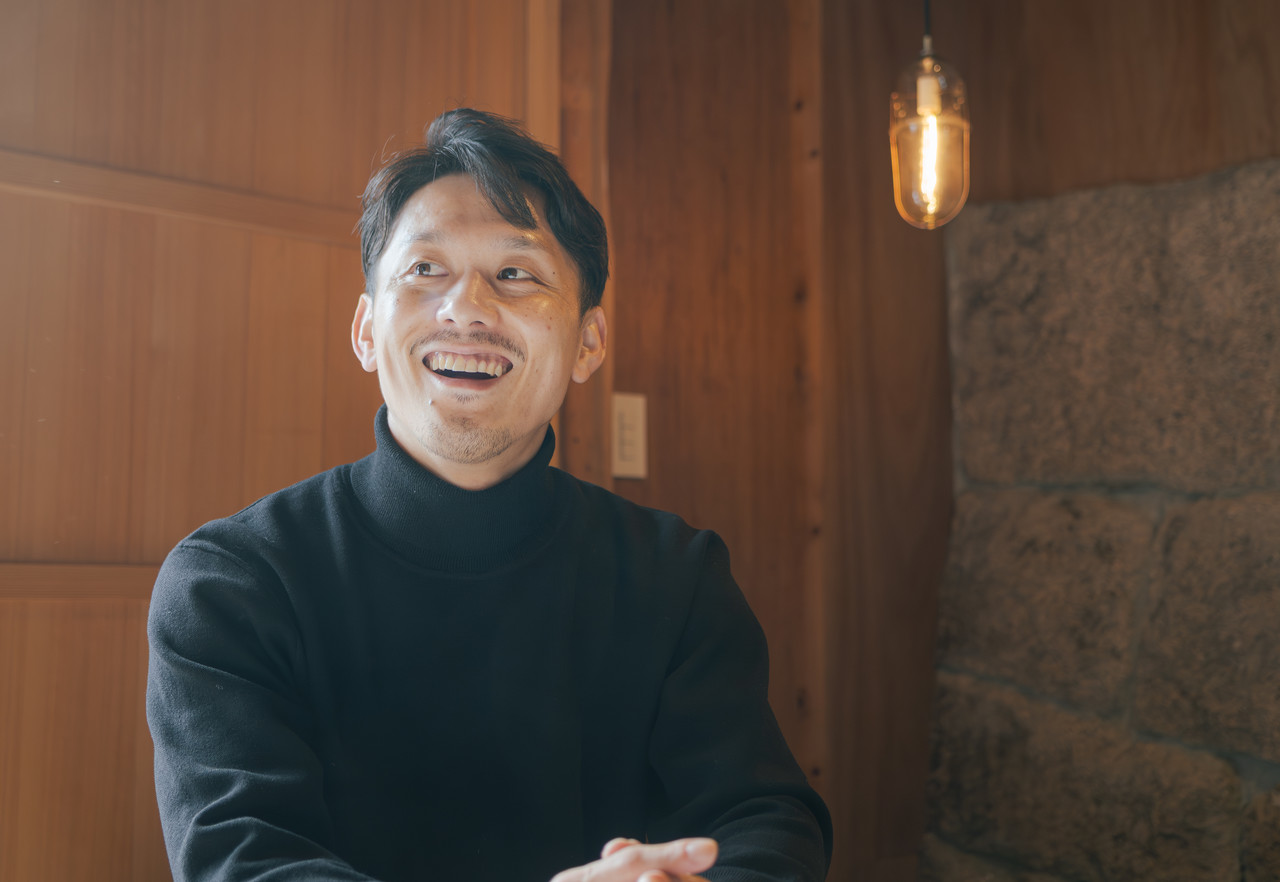 室内で笑顔で話をする男性