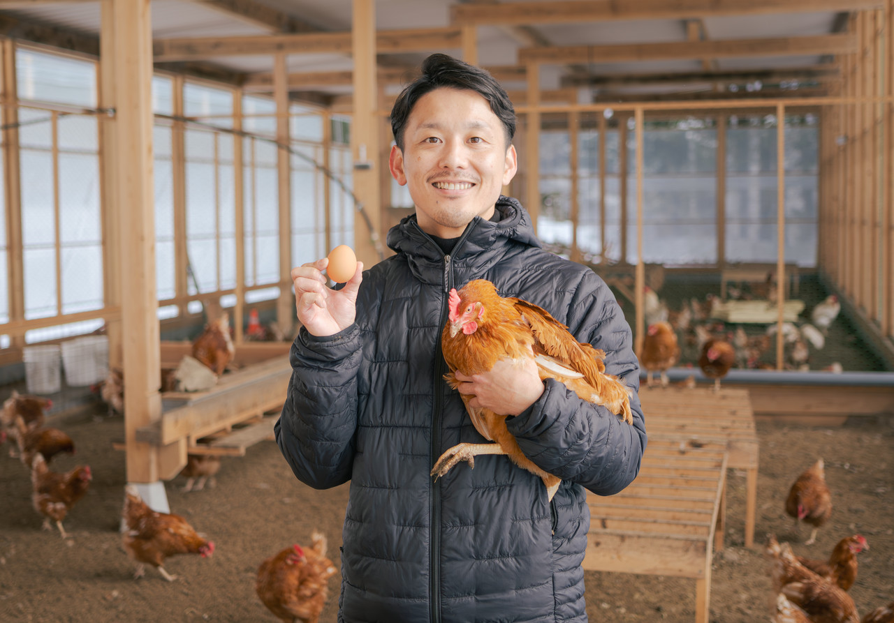 鶏と卵を持つ男性