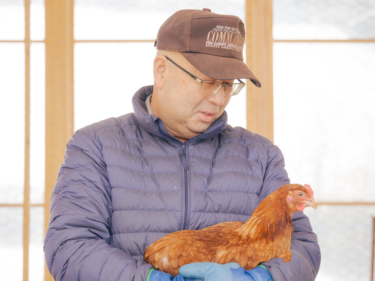 鶏を抱える男性