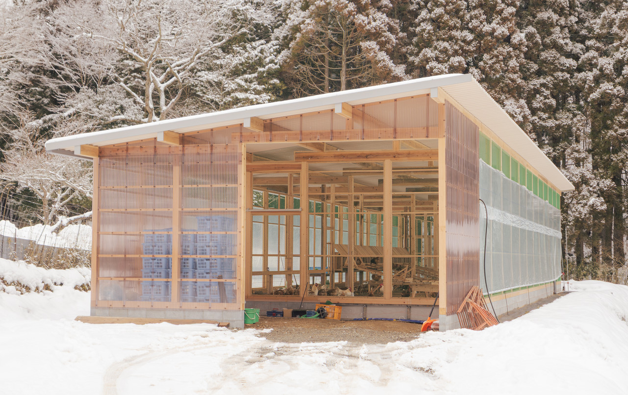 雪景色の中にある木造鶏舎の外観
