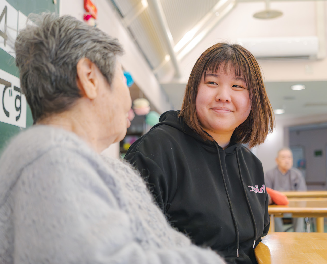 木原向葵さんが高齢の利用者と笑い合っている様子