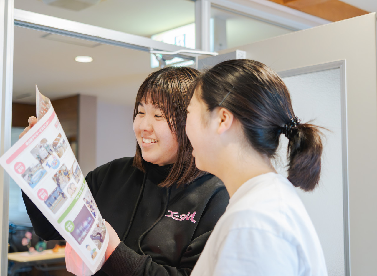 木原向葵さんが別の職員と一緒に資料を見ながら笑っている様子