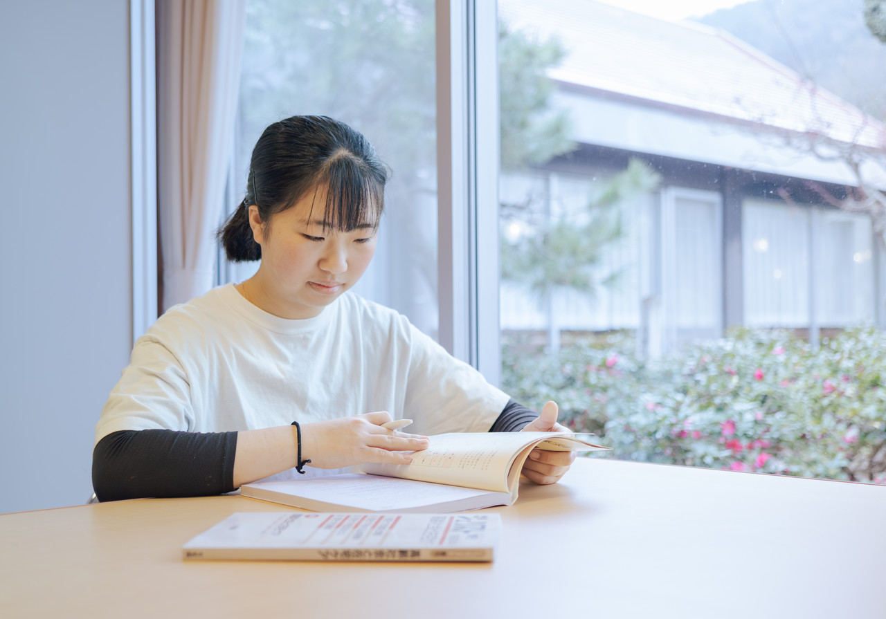 介護スタッフがテキストを開き、資格取得やスキルアップに向けて勉強している様子