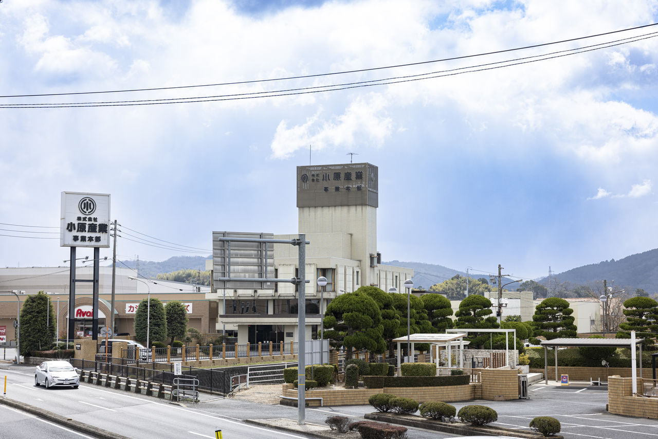 道路沿いにある株式会社小原産業の事業本部の建物の外観。