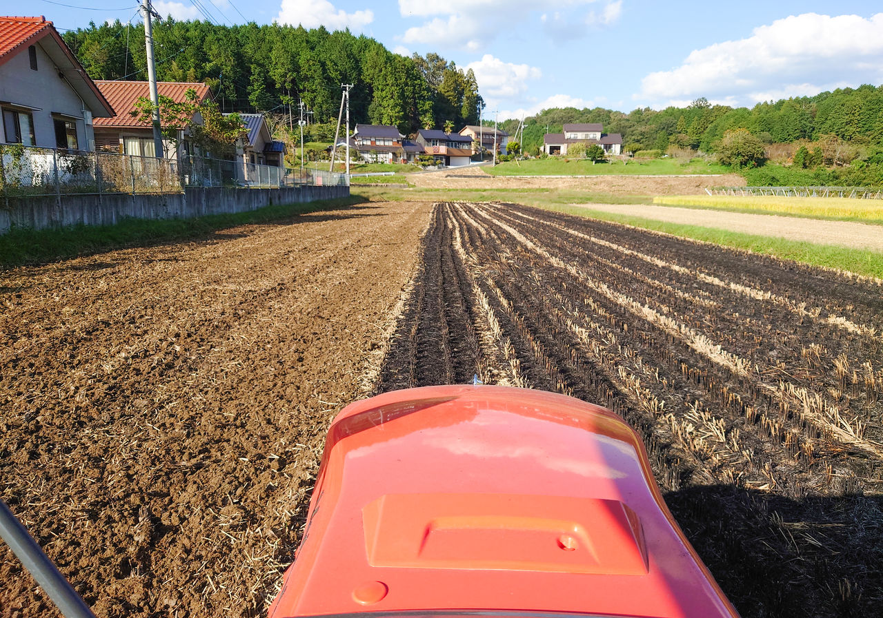 トラクターの運転席から見た、田植え前の水田でのしろかき作業の様子。