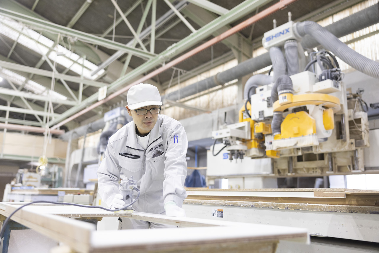 大型機械を使ってカウンター材を加工するスタッフ