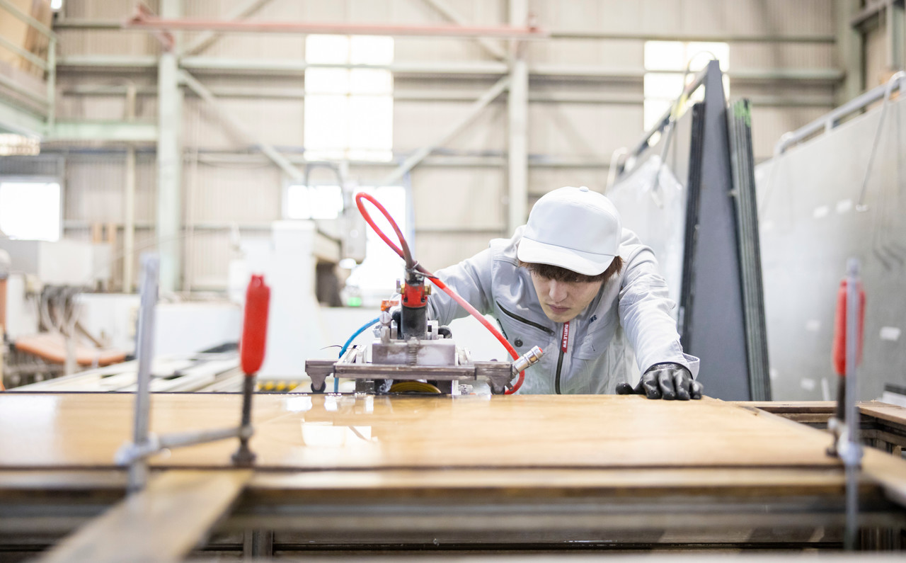 機械を使用して天板を研磨するスタッフ