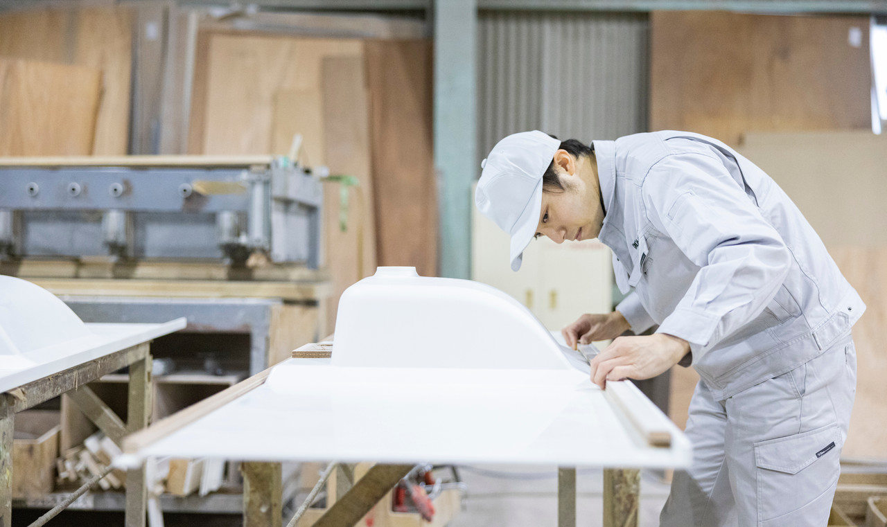 キッチン天板の裏に木材を貼っている社員