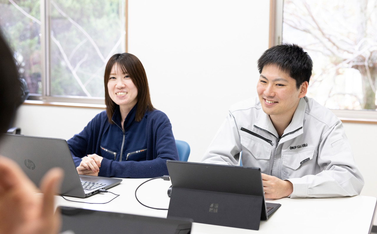 オフィスでパソコンを見ながら会話する三村さんとスタッフ2名