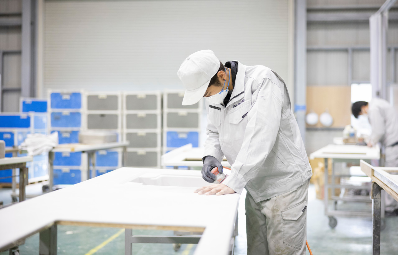 カウンター材の表面を電動ヤスリで研磨するスタッフ