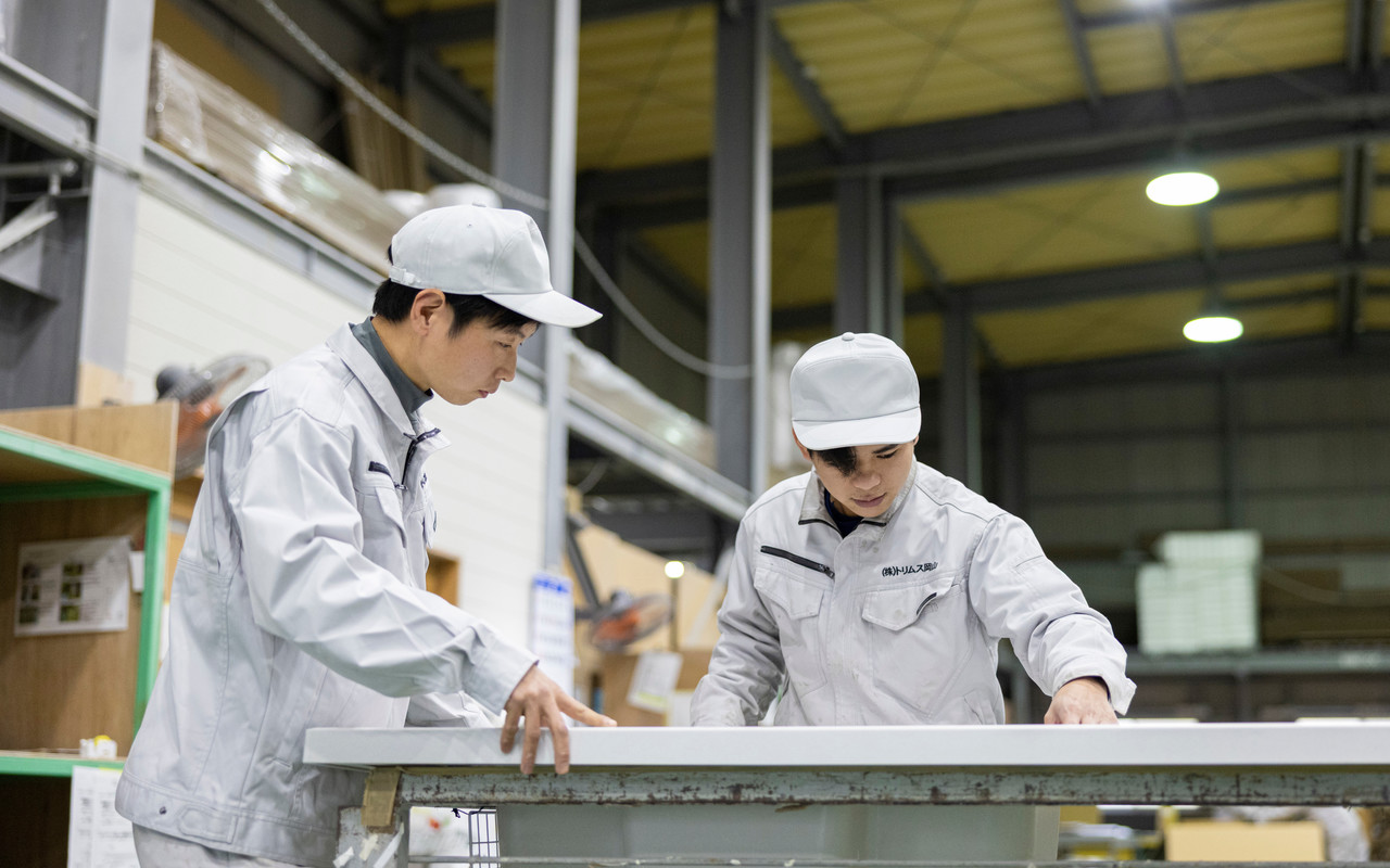 白いカウンター材を確認する工場スタッフ2名