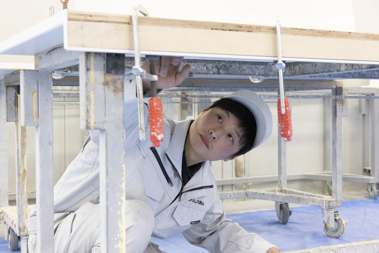 カウンター材の裏側をのぞき込んで確認する吉尾さん