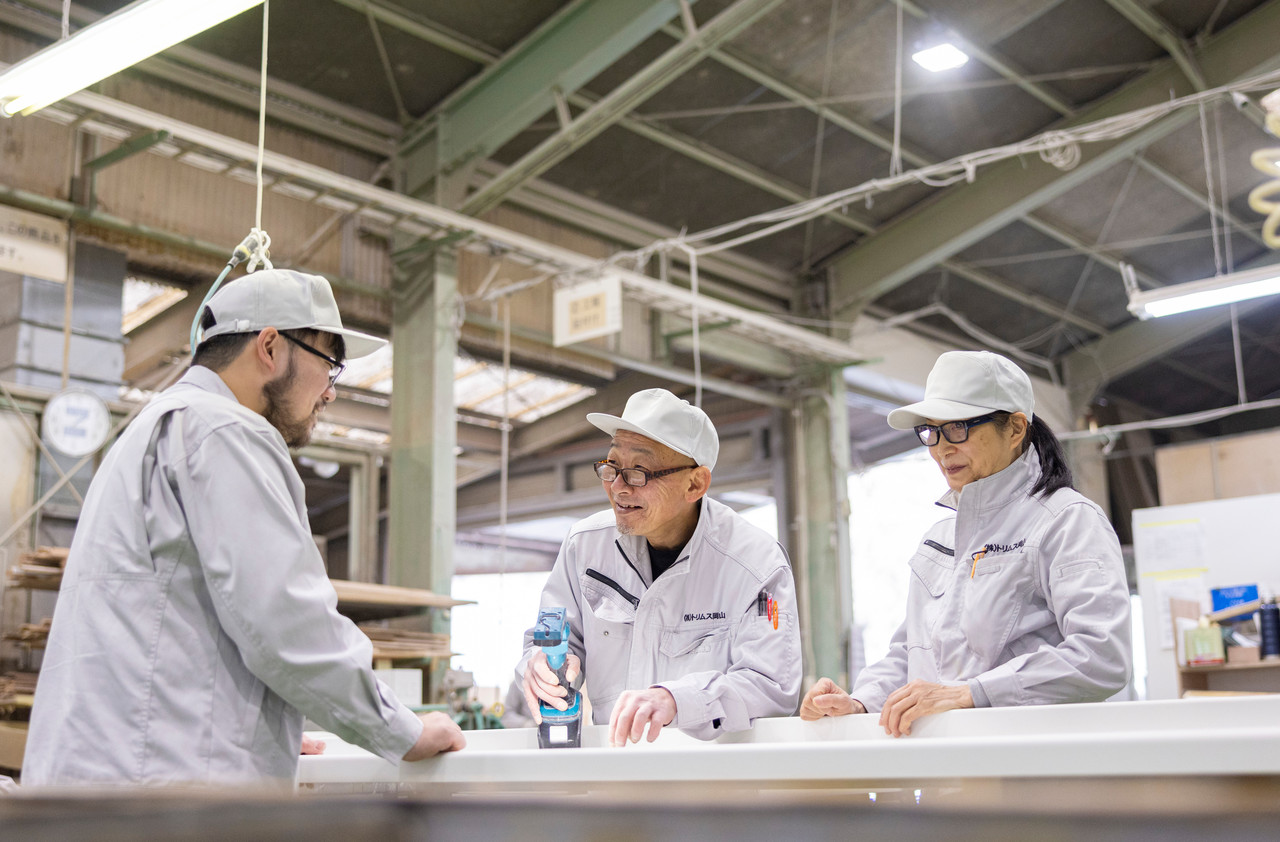 カウンター材を前に相談する3名の工場スタッフ