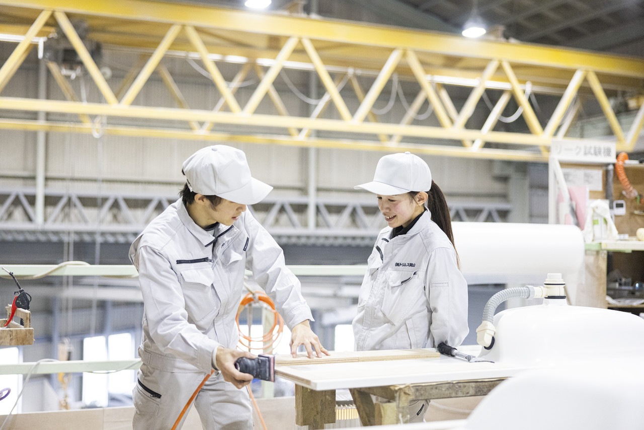 カウンター材を研磨しながら会話する2名のスタッフ