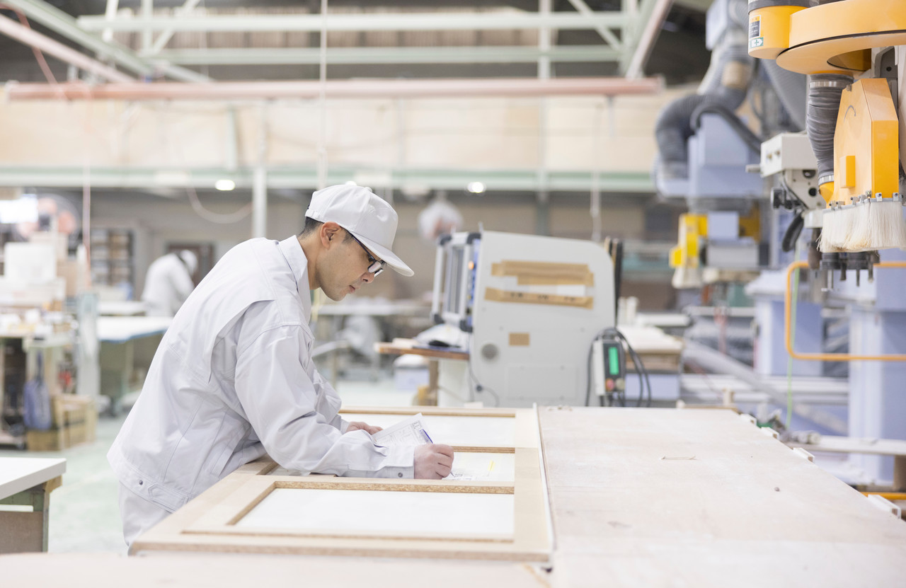 カウンター材の上で図面に書き込みをする川上さん