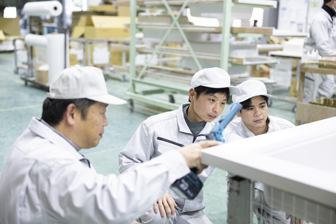 ライトを使って複数人で製品の確認を行うスタッフ