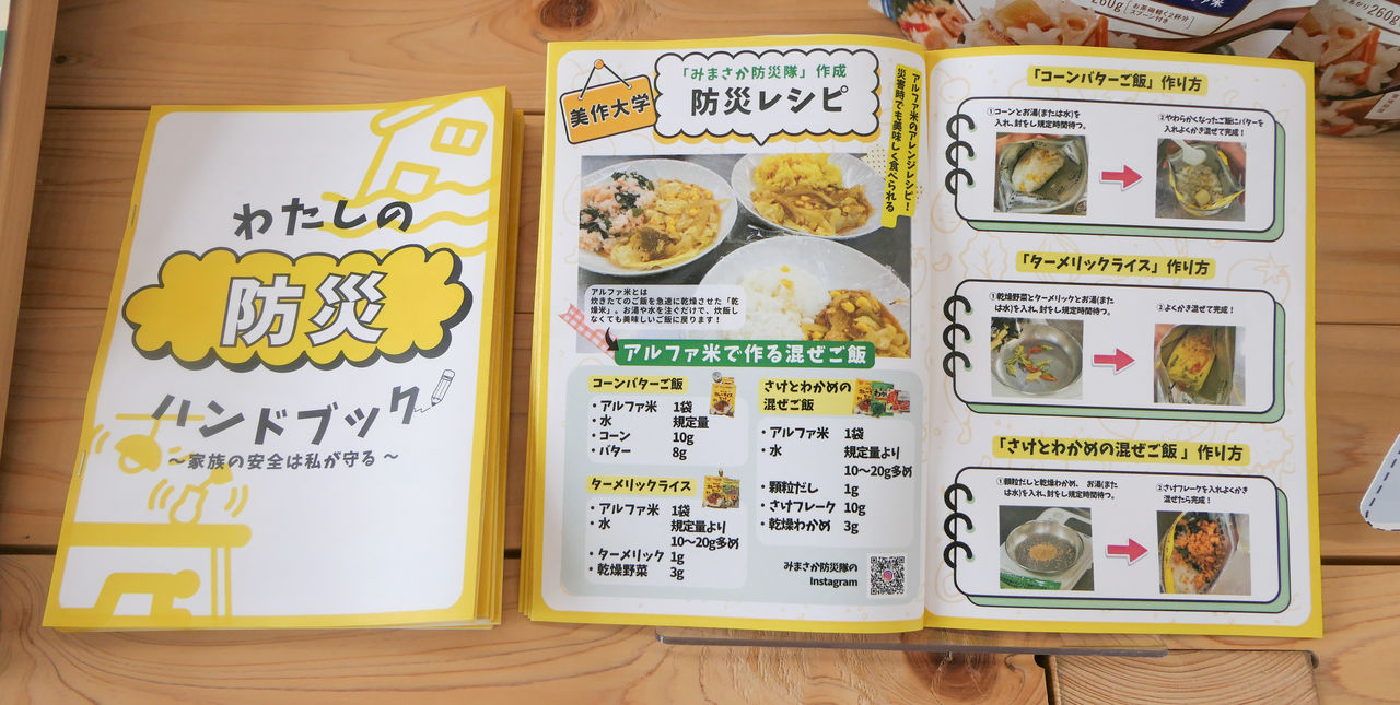 木の机の上に広げられた「わたしの防災ハンドブック」と、美作大学作成の「防災レシピ」。アルファ米で作る混ぜご飯の作り方が写真付きで紹介されている。