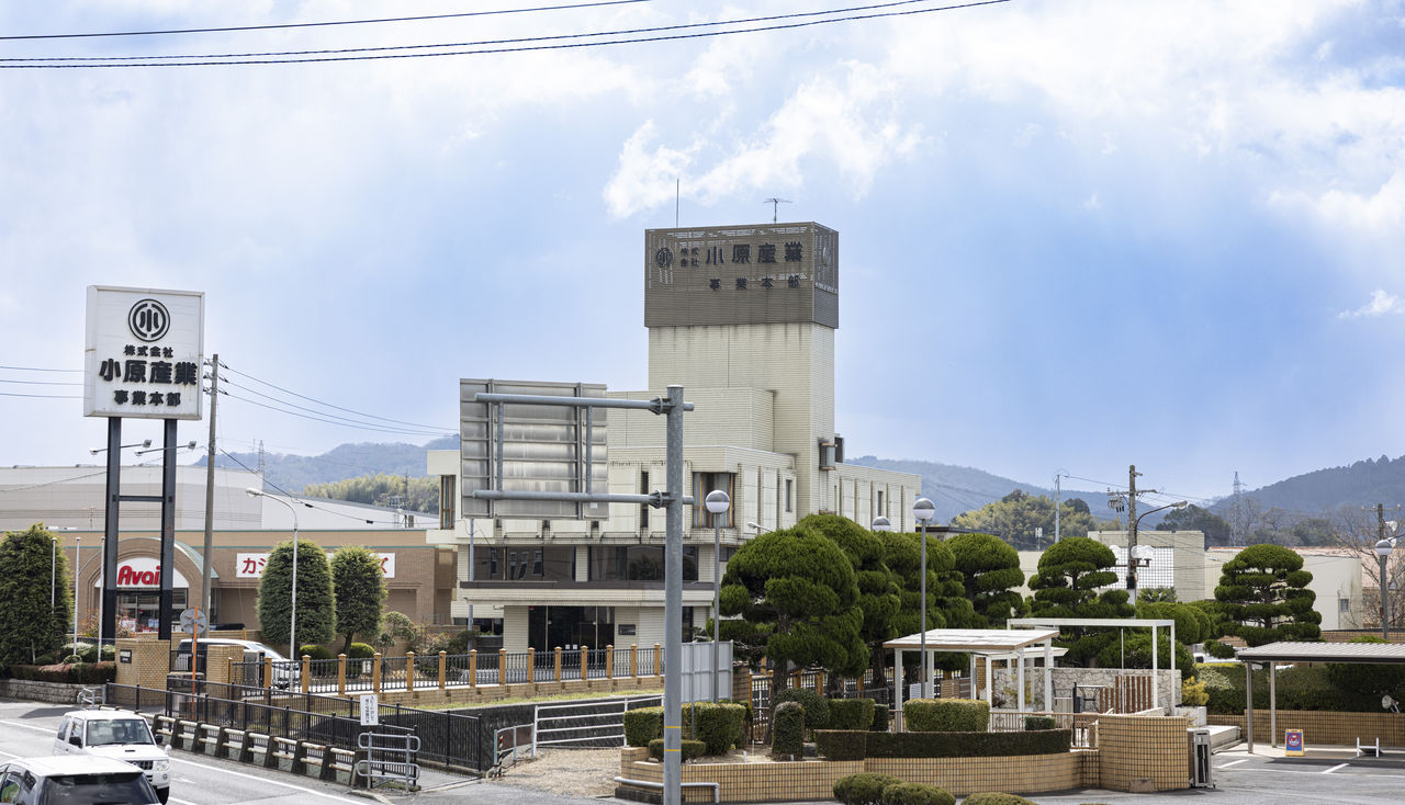 道路沿いにある株式会社小原産業の本社事業本部の建物の外観。