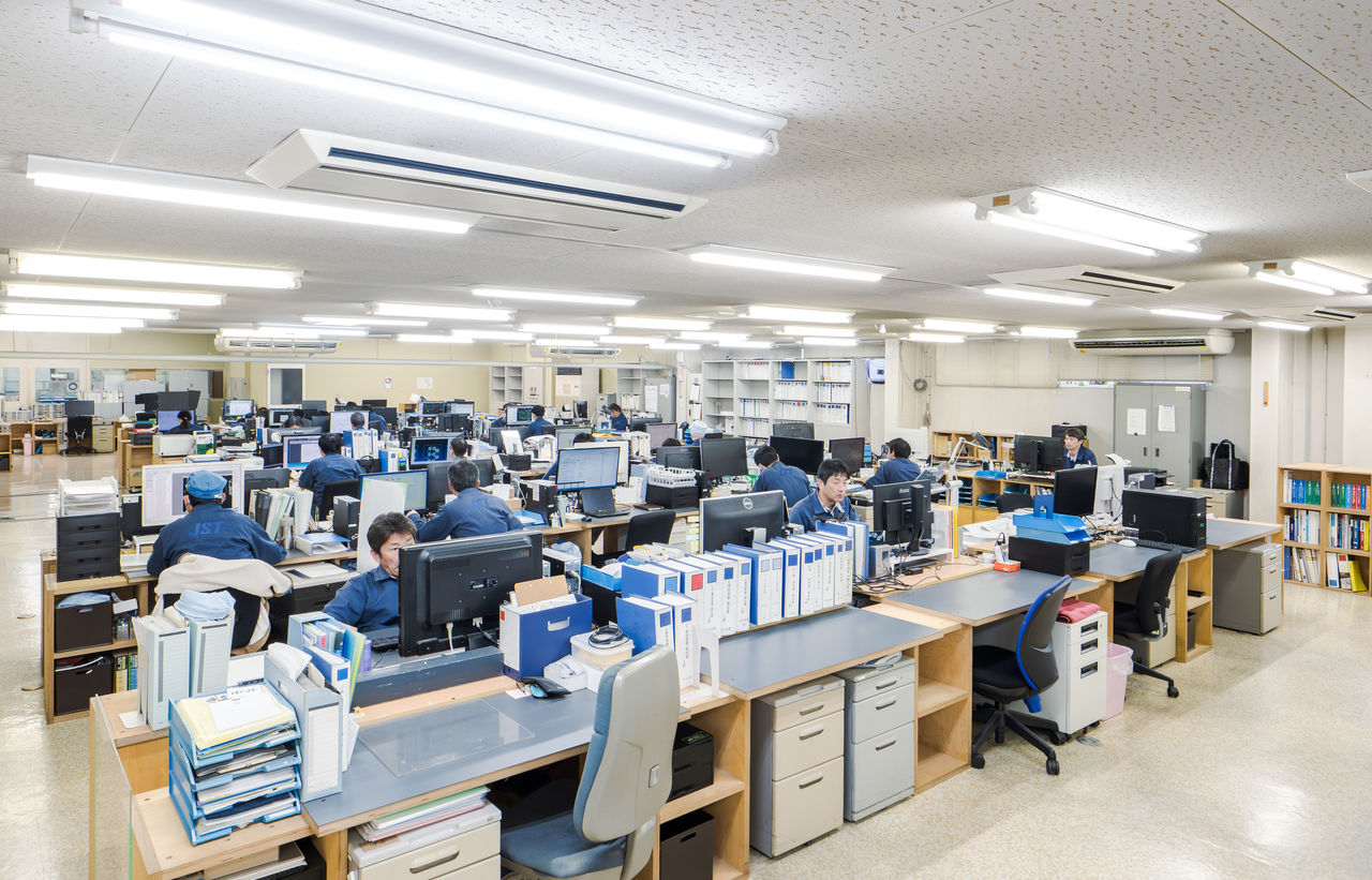 多数のデスクが並び、多くの社員がパソコンに向かって作業をしている設計オフィスの全景