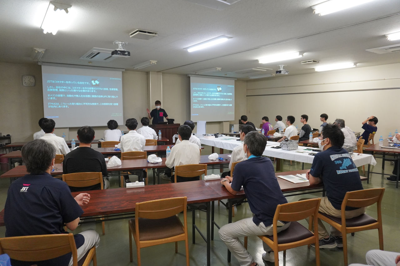 社員が、見学に訪れた学生たちに向けてプロジェクターを使用しながら説明している様子