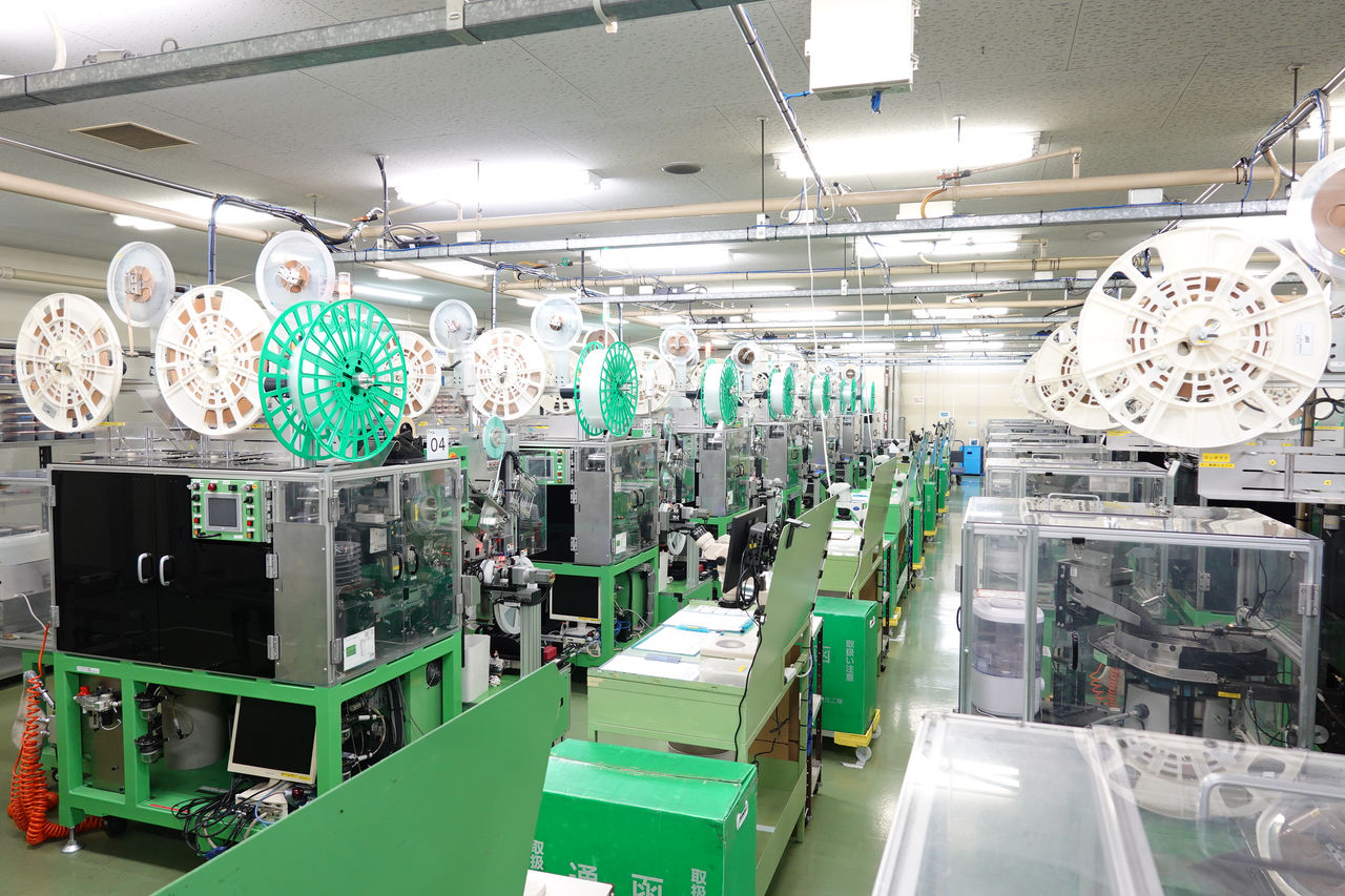 工場内に、透明なケースで覆われた機械設備が並んでいる様子