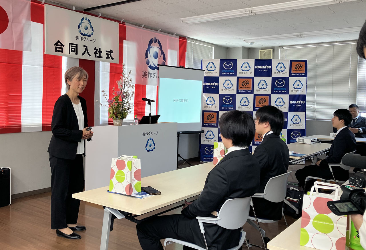 プロジェクターを使用し、着席する新入社員に向けて特別講演を行っている大部由美さんの様子。