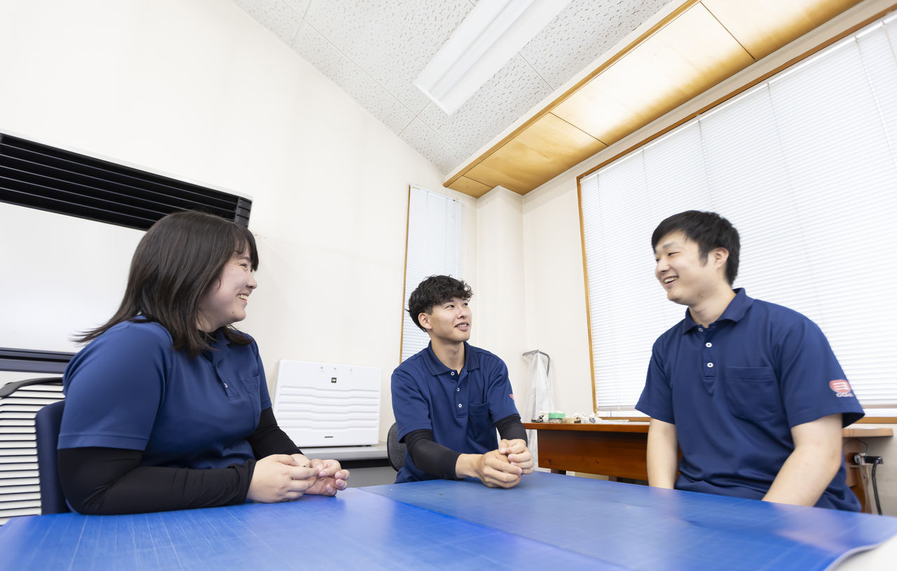 テーブルを囲んで和やかな雰囲気で談笑する社員たち