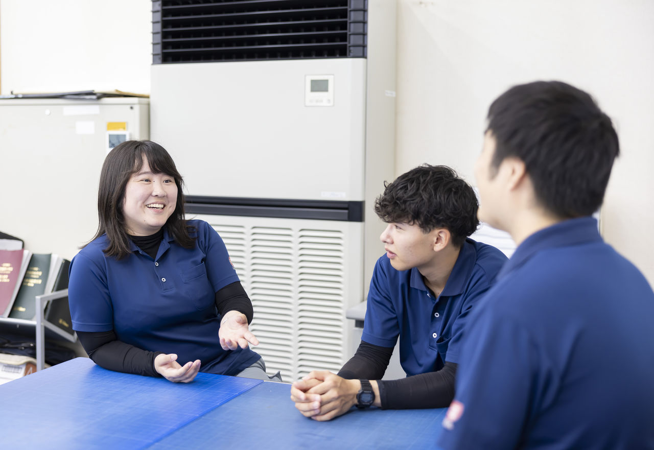 同僚たちとテーブルを囲み笑顔で身振りを交えて楽しそうに話す長嶋奈津美さん