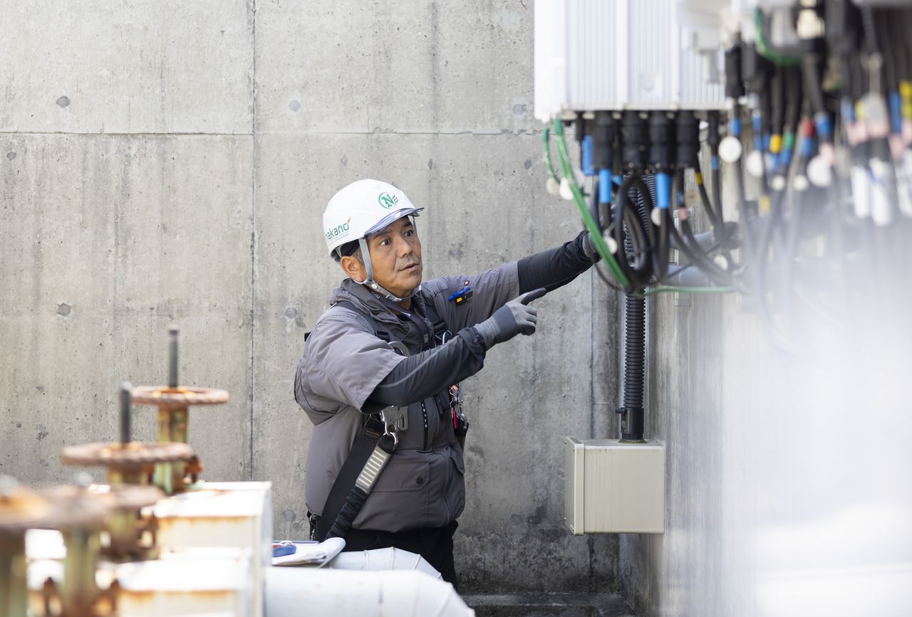制御盤の前で指差し確認を行う作業員