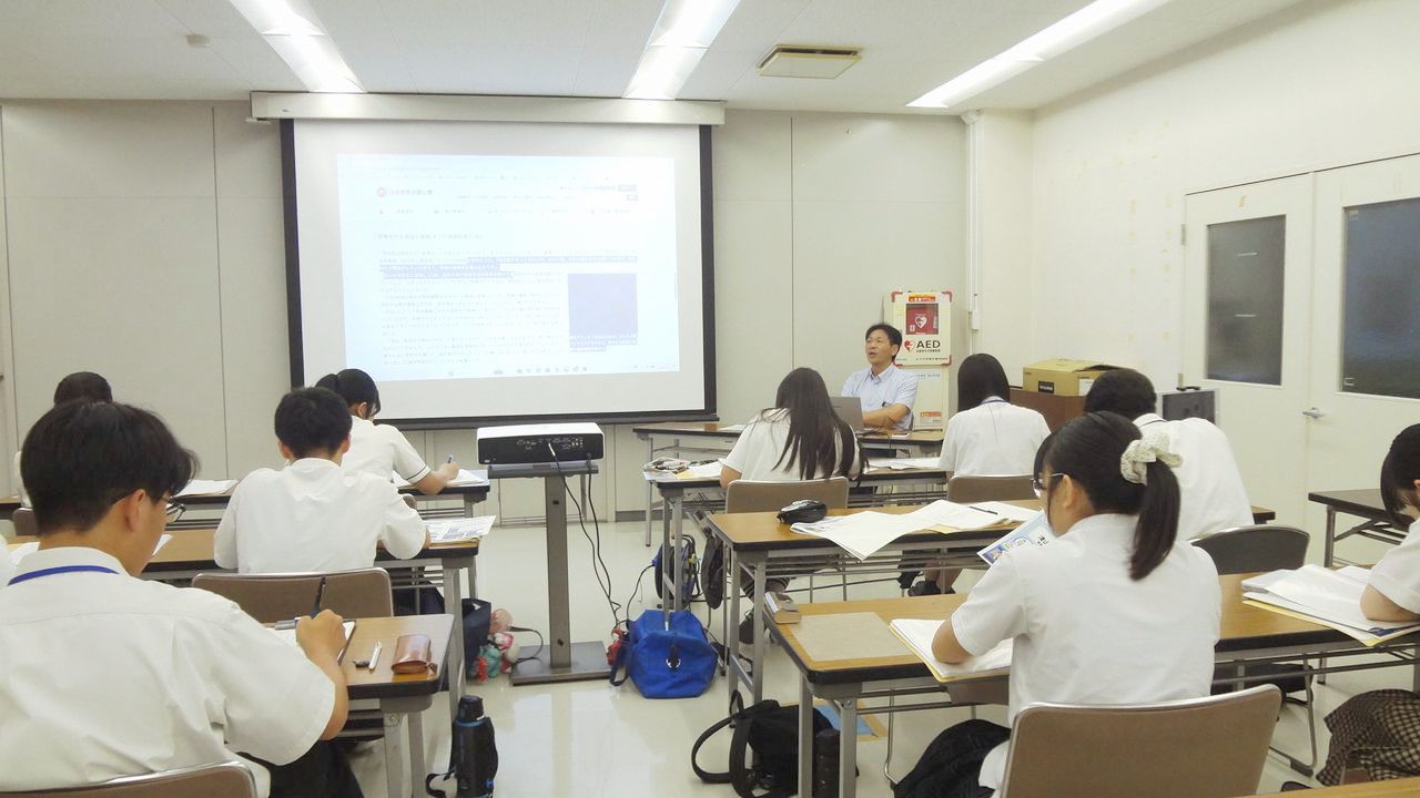 研修室で机に向かい資料やノートを手にする沼泰弘さんと高校生たち